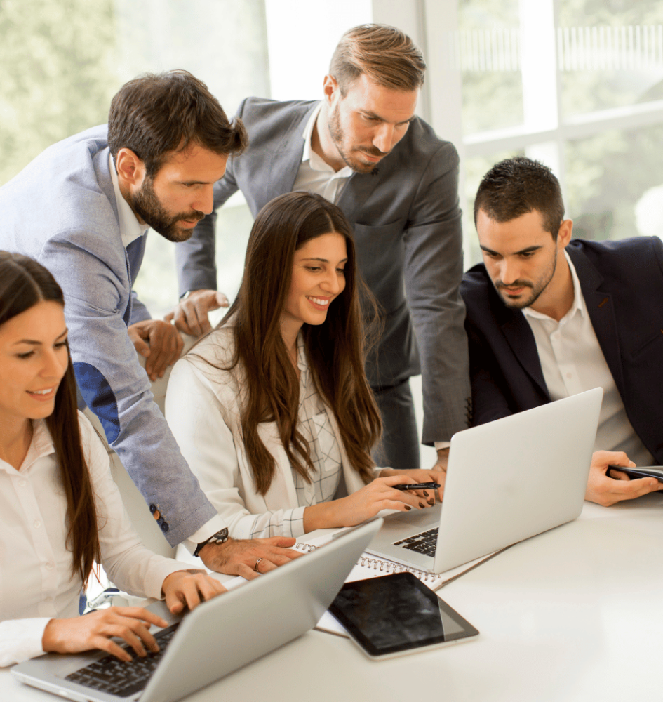 A group of people discussing by seeing laptops